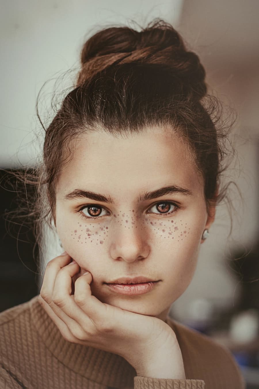 A woman resting a hand against her cheek
